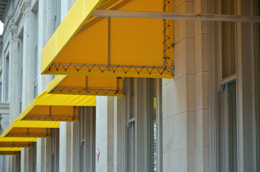 Yellow awnings installed over a building's windows