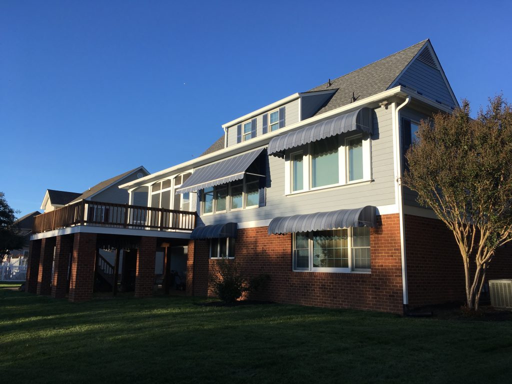 Dark fabric window awnings installed on a brick home in Central Virginia