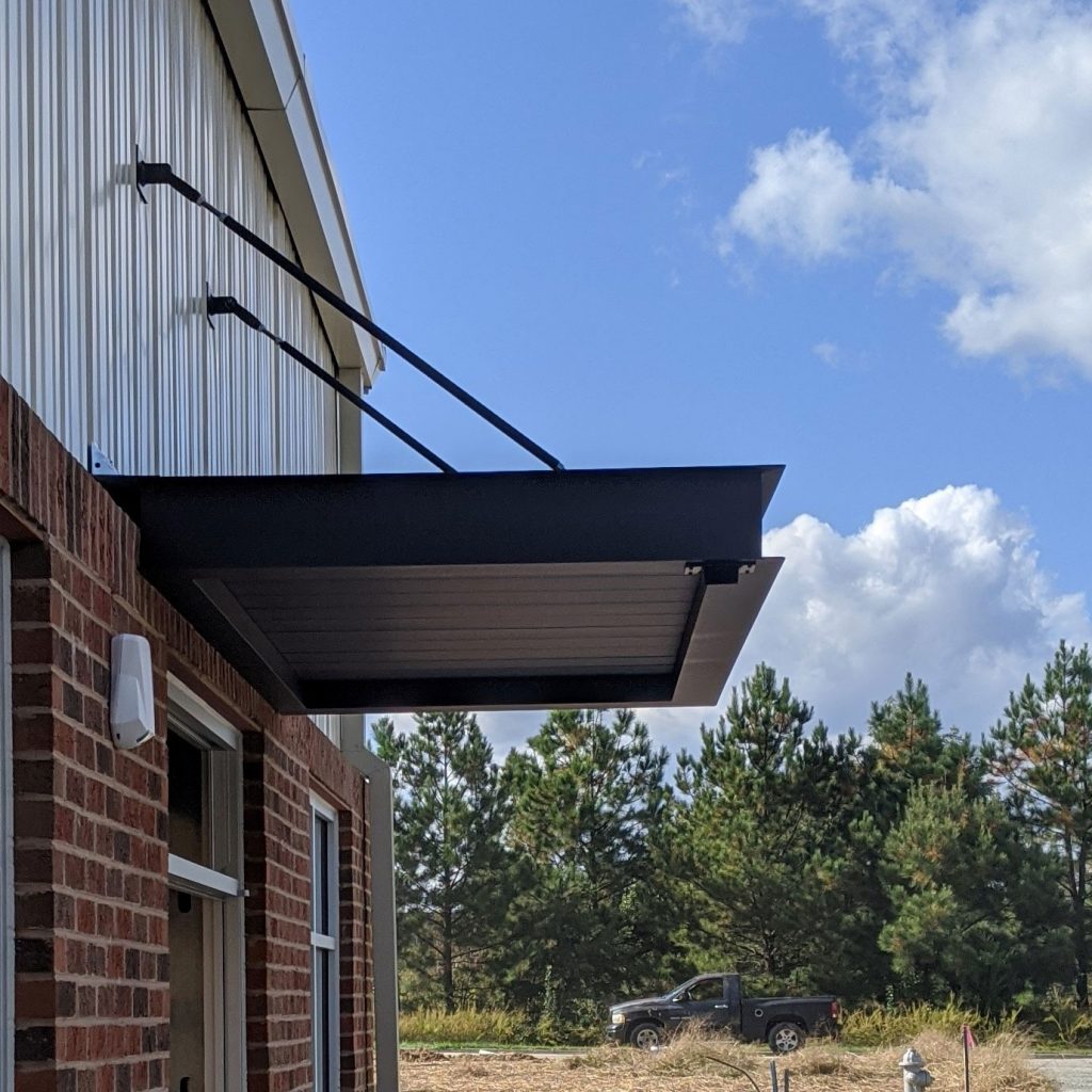 Metal overhead canopy installed above a doorway on a commercial building